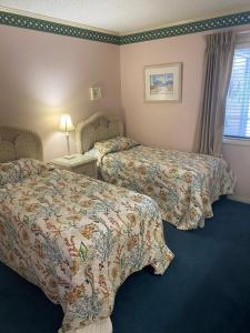 a hotel room with two beds and a window at Seasons In The Sun in North Myrtle Beach +23 photos