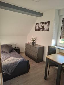 a bedroom with a bed and a desk and a table at Ferienwohnung Familie Siegl in Pouch