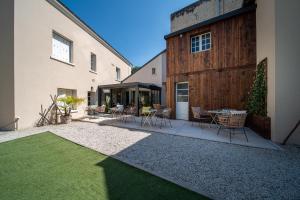 eine Terrasse mit Stühlen und einem Tisch neben einem Gebäude in der Unterkunft Hôtel Rive Sud in Chinon