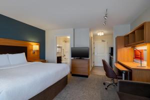 a hotel room with a bed and a desk and a television at TownePlace Suites by Marriott Albuquerque North in Albuquerque