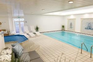 a large swimming pool in a room with a swimming pool at Hygge Suite Sylt Kampen in Niederdorla