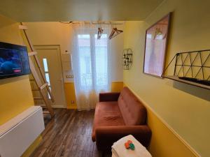 Una sala de estar con un sofá y un televisor. en 2D- Studio tout équipé confort 5stars Idéal proche Paris, en Issy-les-Moulineaux