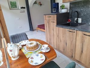a kitchen with a table with a cake on it at Froschteichhäuschen - Natur und Wellness in Spitzwiesen +19 photos