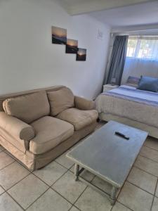 a living room with a couch and a bed at Ulu Garden Cottage in Ramsgate