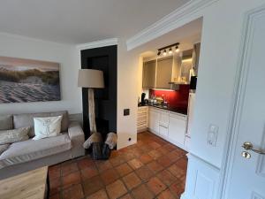a living room with a couch and a kitchen at Hygge Suite Sylt Kampen in Niederdorla