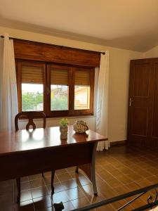 Un comedor con una mesa y una ventana. en DA BARBARINA Casa Vacanze sud Sardegna, en Capoterra