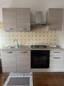 una cocina con fregadero y estufa en DA BARBARINA Casa Vacanze sud Sardegna, en Capoterra 7 fotos más