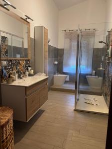 Un baño grande con dos lavabos y una ducha. en DA BARBARINA Casa Vacanze sud Sardegna, en Capoterra