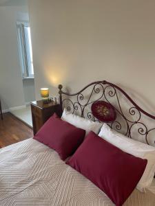 a bedroom with a large bed with red pillows at Camere al Borgo Affittacamere in Monteprandone