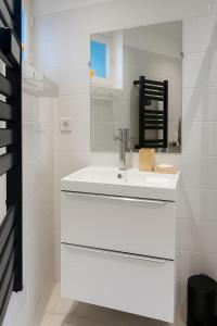 a white bathroom with a sink and a mirror at Appartement Mao in Brignoles