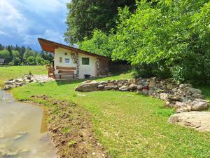 a small house with a stone path next to a river at Froschteichhäuschen - Natur und Wellness in Spitzwiesen