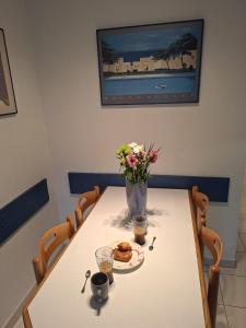a table with a plate of cookies and a vase of flowers at Marina Cocon – Appartement 2 pièces en rez-de-jardin à Villeneuve-Loubet in Les Beaumettes
