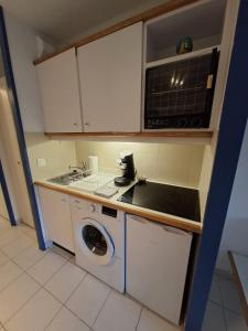 a kitchen with a washing machine and a microwave at Marina Cocon – Appartement 2 pièces en rez-de-jardin à Villeneuve-Loubet in Les Beaumettes