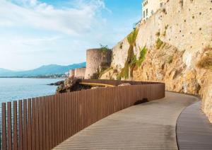 a walkway next to a wall next to the water at Citabella Bastia in Bastia