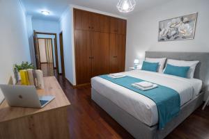 a bedroom with a bed with a laptop on a desk at Apartamento Isabel Charmoso e bem localizado in Ribeira Brava