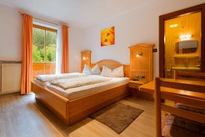 a bedroom with a bed and a sink and a window at Garni Bergland in Racines