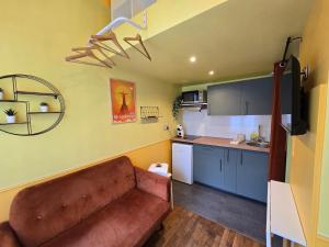 Una sala de estar con un sofá y una cocina. en 2D- Studio tout équipé confort 5stars Idéal proche Paris, en Issy-les-Moulineaux