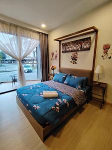 a bedroom with a large blue bed and a window at Timurbay Seafront By Moonlight in Kuantan