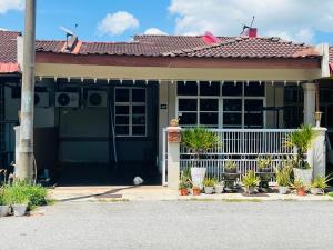 a house with a blue door and potted plants at FS Homestay Jitra in Jitra
