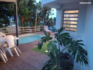 un patio con piscina, mesa y sillas en Villa PERGOLA, en Fort-de-France 3 fotos más