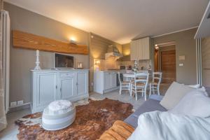 a living room with a couch and a kitchen at Prato Nevoso - Macalù Ski Apartment - GrandMaison in Prato Nevoso +22 photos