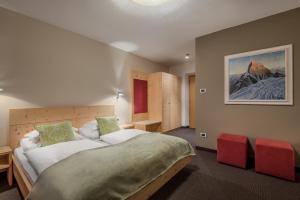 sypialnia z dużym łóżkiem i czerwonymi krzesłami w obiekcie Gasthof Traube w mieście San Lorenzo di Sebato