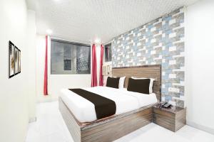 a bedroom with a large bed and a brick wall at Hotel O Pragati in Jairāmpura +22 photos