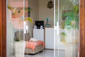 ein Zimmer mit einem Bett und einer Glastür in der Unterkunft Flats Tartaruga Búzios in Búzios