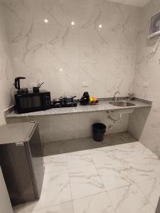 a kitchen with a counter with a sink and a microwave at DHB Stays Luxury Downtown Apartment 1BR 89 in Cairo