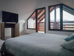 a bedroom with a bed and a flat screen tv at Cazare Conacul Tusinean in Petreştii de Jos