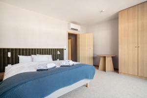 a bedroom with a bed with two towels on it at Forest & Waves - Luxury Seaside Retreat with Pool, 90m to the Beach & Pro Workstations in Łukęcin +25 photos