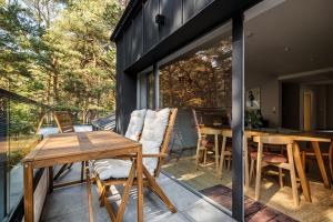a screened in porch with a table and chairs at Forest & Waves - Luxury Seaside Retreat with Pool, 90m to the Beach & Pro Workstations in Łukęcin