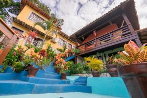 ein Haus mit blauen Treppen und Topfpflanzen in der Unterkunft Flats Tartaruga Búzios in Búzios