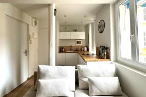 a kitchen with two white chairs and a counter at Il Piccolo - Cosy emplacement de rêve in Bandol