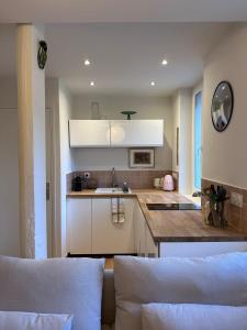 Una cocina con gabinetes blancos y encimera. en Il Piccolo - Cosy emplacement de rêve, en Bandol