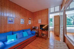 a living room with a blue couch and a television at Petit Colibri - Proche de la plage in La Baule