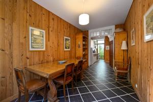 a dining room with a wooden table and chairs at Petit Colibri - Proche de la plage in La Baule +4 photos