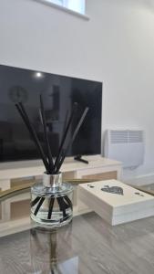 a glass vase with sticks in it on a table at Flat 8, Cupar Apartments. in Fife