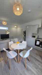 a living room with a table and chairs and a kitchen at Flat 8, Cupar Apartments. in Fife