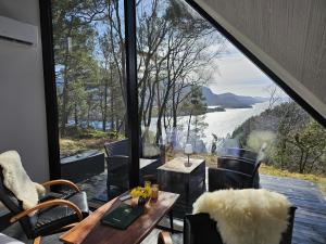 a room with a table and chairs and a large window at NorGlamp Glamping in Hjelmeland