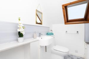 Un baño blanco con lavabo e inodoro. en The Steading, Kingsbarns., en Kingsbarns 16 fotos más