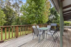 a patio with a table and chairs on a deck at Carmelia Garden View Haven for Families and Friends in Wentworth Falls