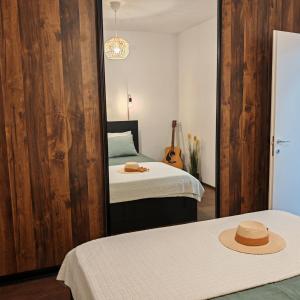 a bedroom with two beds and a mirror with a hat at The Golden View Apartment in Split