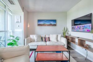 a living room with a couch and a table at Chic 1BR plus Den Condo with Fast WiFi and Free Parking in Toronto
