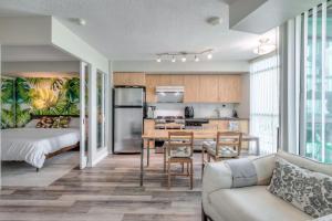 a kitchen and living room with a couch and a table at Chic 1BR plus Den Condo with Fast WiFi and Free Parking in Toronto