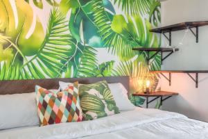 a bedroom with a bed with a tropical wallpaper at Chic 1BR plus Den Condo with Fast WiFi and Free Parking in Toronto