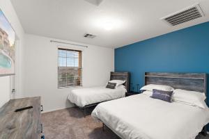 a bedroom with two beds and a blue wall at Mountain View Retreat Pool, Firepit Pool table Fun in Casa Grande +48 photos