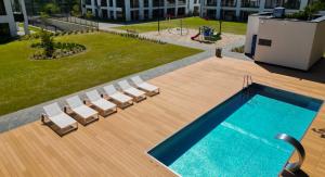 a swimming pool with lounge chairs and a swimming pool at Forest & Waves - Luxury Seaside Retreat with Pool, 90m to the Beach & Pro Workstations in Łukęcin