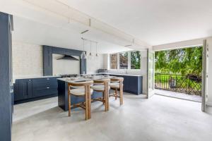 a kitchen with blue cabinets and a large window at Balbirnie Mill, Brechin. in Angus