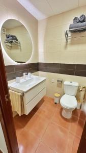Un baño con lavabo, inodoro y espejo. en Nomad Haux in the heart of Tossa 5, en Tossa de Mar